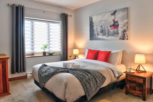 1 dormitorio con cama con almohadas rojas y remonte en L'Algonquin A en Mont-Tremblant