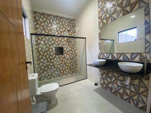 a bathroom with a toilet and a sink and a mirror at CASA BRISA MAR DELUXE - Maragogi in Maragogi