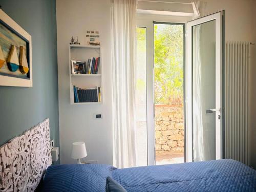 Un dormitorio con una cama azul y una ventana. en Casa Marina, en Tellaro