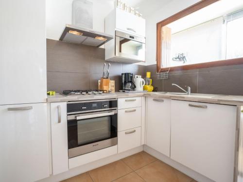 une cuisine blanche avec une cuisinière et un évier dans l'établissement Apartment Le Paradou by Interhome, à La Ciotat