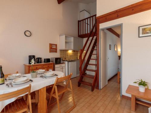 une cuisine et une salle à manger avec une table et un escalier dans l'établissement Holiday Home Les Charmilles-10 by Interhome, aux Mathes