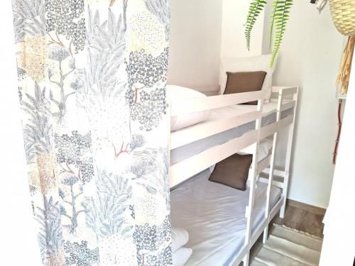 Ce lit superposé se trouve dans une petite chambre dotée d'un rideau. dans l'établissement Studio rénové avec terrasse 40 m 2, à Palavas-les-Flots