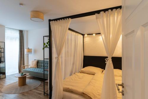 ein Schlafzimmer mit einem Himmelbett und einem blauen Sofa in der Unterkunft bevoflats - Zentrales Souterrain in Kreuzberg in Berlin