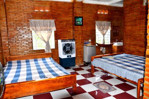 a room with two beds and a television in it at BOSA Homestay - Mekong Riverside in Can Tho