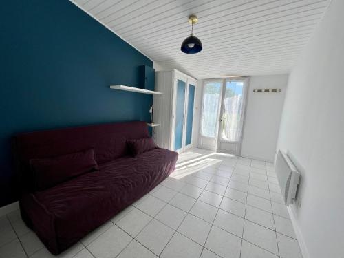 a living room with a couch and a blue wall at Chez Laurie et Xavier studio 4 in Mignaloux-Beauvoir