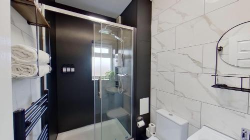 a bathroom with a glass shower and a toilet at Elegant 2 Bed House Near City Centre in Manchester