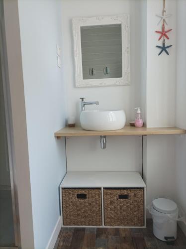 une salle de bain avec un lavabo et un miroir dans l'établissement Gite à Yport, à Yport