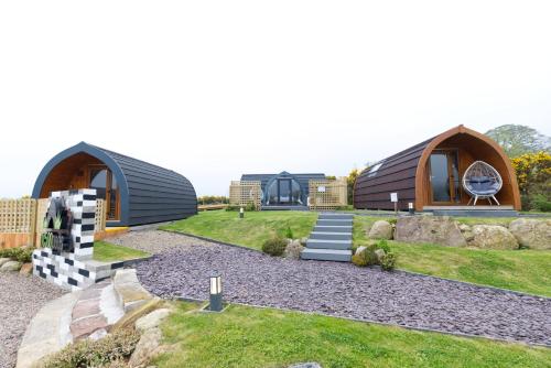 una casa con techo de gambrel y un patio en North Coast 500 Pods - Brora, en Brora