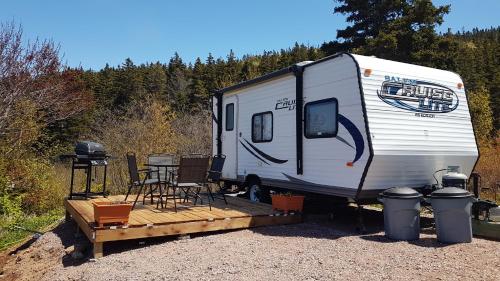 a white trailer with a table and chairs in it at Moceanset Getaways-Beautiful Ocean, Mountain & Sunset Views in Dingwall