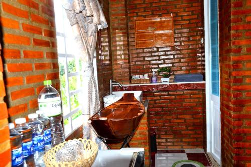 baño con lavabo y pared de ladrillo en BOSA Homestay - Mekong Riverside, en Can Tho