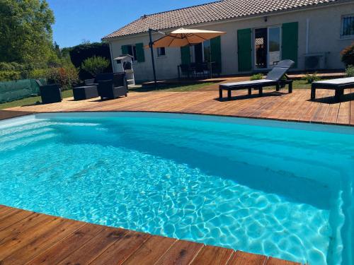 une grande piscine bleue avec une terrasse en bois dans l'établissement Maison spacieuse avec piscine, à Hinx