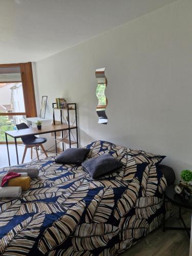 Un dormitorio con una cama con almohadas encima. en Joli studio une pièce 15min à pied centre dEpinal 4 personnes grâce au canapé lit, parking privé gratuit et parking extérieur gratuit Machine à laver TV wifi machine à café linge de lit et serviettes fournis, en Chantraine