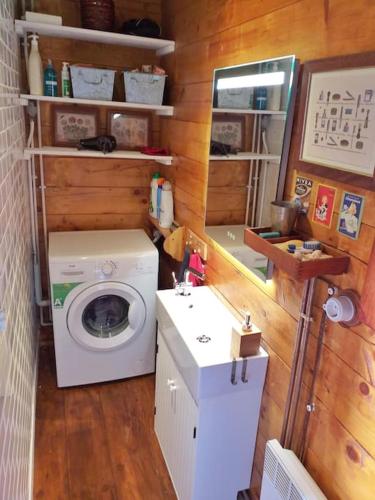 une petite salle de bains avec un lave-linge et un lavabo dans l'établissement Chalet familiar con jardín y garage privado, à Bolquère-Pyrénées 2000