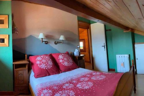 une chambre avec un lit avec des oreillers rouges dans l'établissement Chalet familiar con jardín y garage privado, à Bolquère-Pyrénées 2000