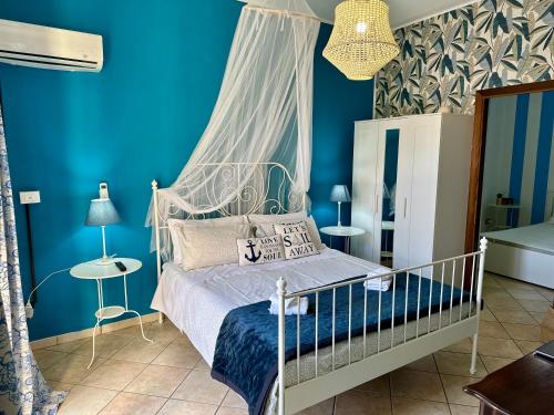 ein Schlafzimmer mit blauen Wänden und einem Bett mit Baldachin in der Unterkunft Case Vanella Grande aspra bagheria in Bagheria