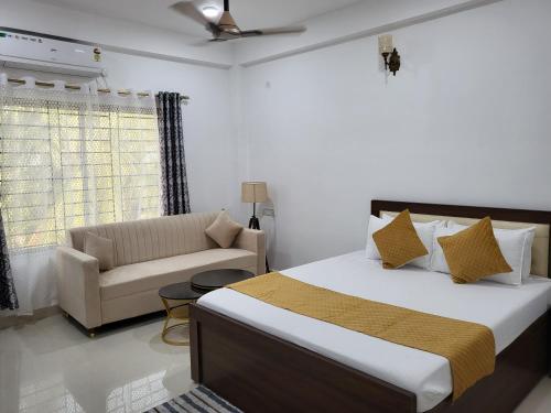 a bedroom with a bed and a couch at Hebron Haven Homestay in Jaigaon