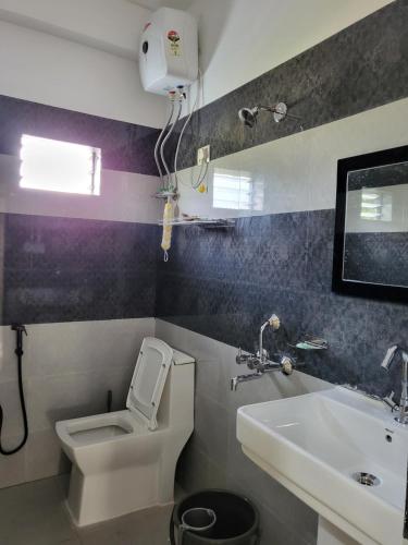 a bathroom with a toilet and a sink at Hebron Haven Homestay in Jaigaon