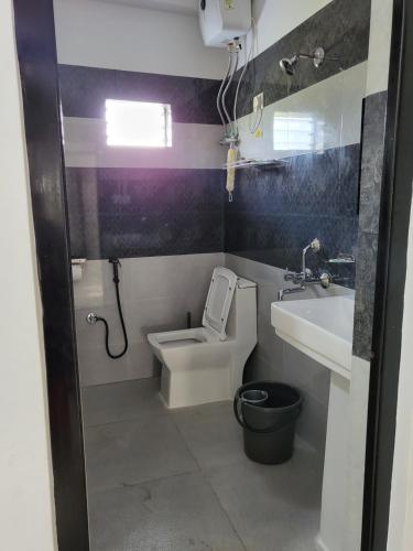 a small bathroom with a toilet and a sink at Hebron Haven Homestay in Jaigaon