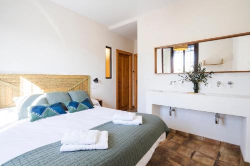 1 dormitorio con 1 cama grande y lavamanos en Complejo Rural en Porcuna-Jaén en Porcuna