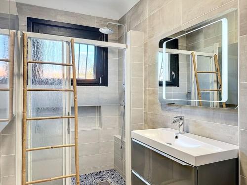 une salle de bain avec un lavabo et un miroir dans l'établissement La Villa Vinsou avec piscine proche golf et océan, à Seignosse