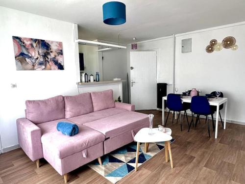 un salon avec un canapé rose et une table dans l'établissement Bel appartement, chambre et salon à Metz centre, à Metz