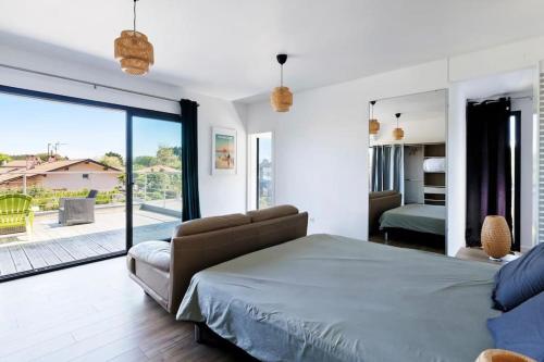 une chambre avec un lit et une porte coulissante en verre dans l'établissement La Villa Vinsou avec piscine proche golf et océan, à Seignosse
