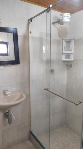 a bathroom with a glass shower and a sink at Hotel Brisas del Nevado in Güicán