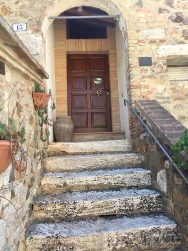 a set of stone stairs leading to a wooden door at Agriturismo Le Querciole in Val d'Orcia in Bagno Vignoni