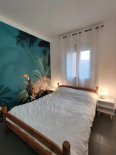 une chambre avec un grand lit avec un tableau au mur dans l'établissement La jungle urbaine avec garage privé & climatisation, à Perpignan