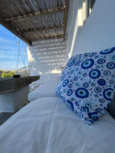 uma cama com uma almofada azul e branca numa varanda em Louloudas rooms paros em Molos Parou