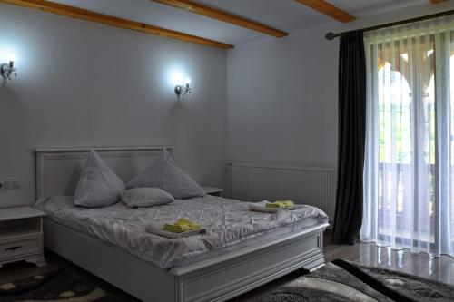 a bedroom with a bed with two plates on it at Pensiunea Maramu in Breb