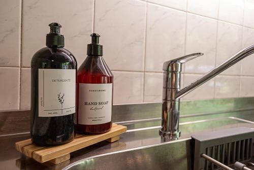 zwei Flaschen Wein auf einer Theke neben einem Waschbecken in der Unterkunft La Casita del Bosque in San Martín de los Andes