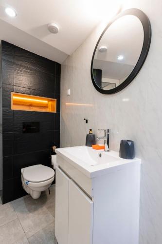 a bathroom with a sink and a toilet and a mirror at Bobevata guest house - Floor 2 - Stunning view Old town in Veliko Tŭrnovo