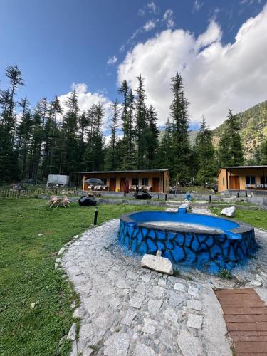 a blue pond in the middle of a field at Infinity Villa and Resort Kumrat Valley in Tāl