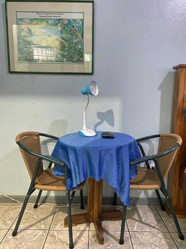 a table with a lamp on it with two chairs at Cabinas Mitchaelle's in Puerto Viejo
