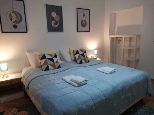 a bedroom with a blue bed with two towels on it at Eisenerzer Apartments - Radmeisterhaus in Eisenerz