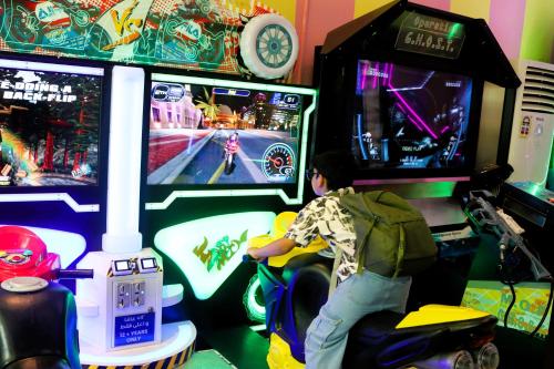 a person playing a video game in a arcade at Lagoona Beach Luxury Resort and Spa in Manama