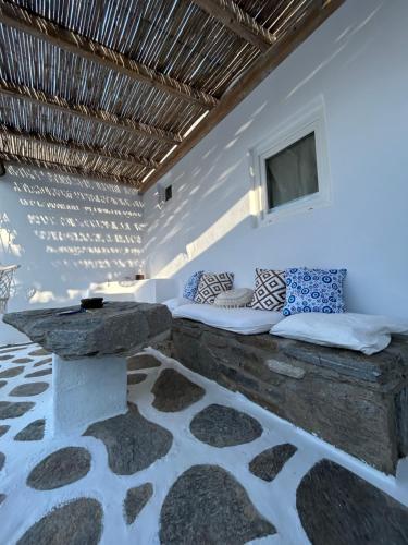 a room with a bed with a table and a window at Louloudas rooms paros in Molos Parou