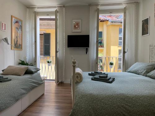a bedroom with two beds and a flat screen tv at Holiday Studio in Centro Storico Intra in Intra