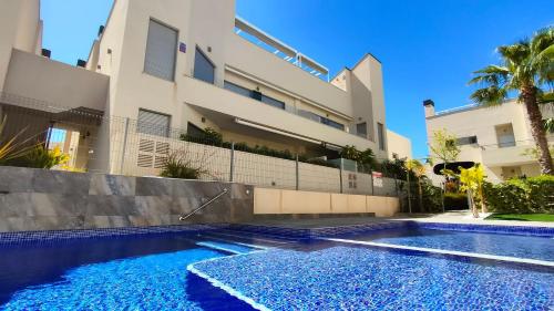 une villa avec une piscine en face d'un bâtiment dans l'établissement Villa Amalia Eco, à Torrevieja