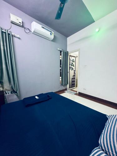 a bedroom with a blue bed and a window at JVA HOMESTAY in Kollam