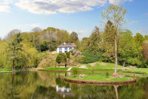 a house on a hill next to a lake at 5 Bedroom Lake House in a nature reserve in Devizes