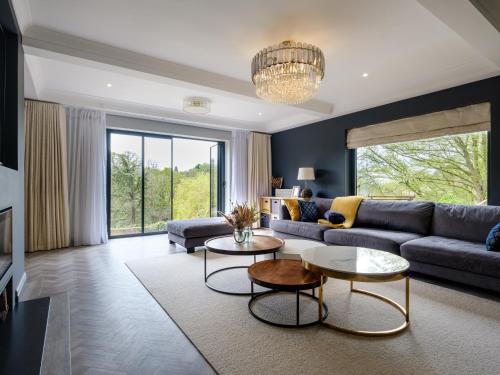 a living room with a couch and a table at 5 Bedroom Lake House in a nature reserve in Devizes