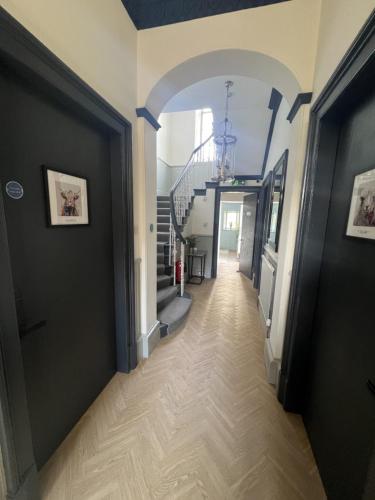 a hallway with an archway and stairs in a house at 9 Bedroom all Ensuite- Exclusive Use in Auchterarder