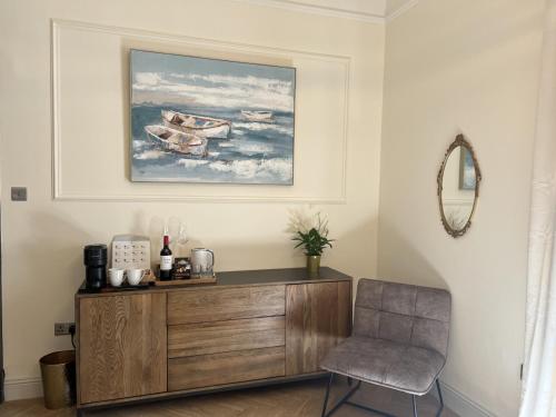 a living room with a wooden dresser and a chair at 9 Bedroom all Ensuite- Exclusive Use in Auchterarder