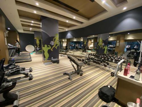 a gym with rows of treadmills and machines at DLF Royal Stay in Lucknow