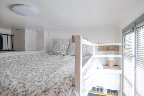 une chambre blanche avec un lit et une fenêtre dans l'établissement charmante studette remblai des sables d olonne, à Les Sables-dʼOlonne