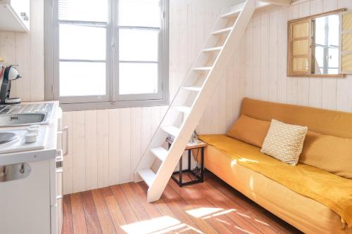 un salon avec un canapé et un escalier dans l'établissement charmante studette remblai des sables d olonne, à Les Sables-dʼOlonne