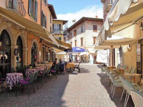 an empty street with tables and chairs and umbrellas at Apartment Adelaide by Interhome in Albisano