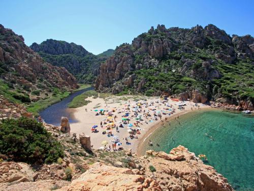 a group of people on a beach near the water at Holiday Home Mare-2 by Interhome in Li Valcaggi